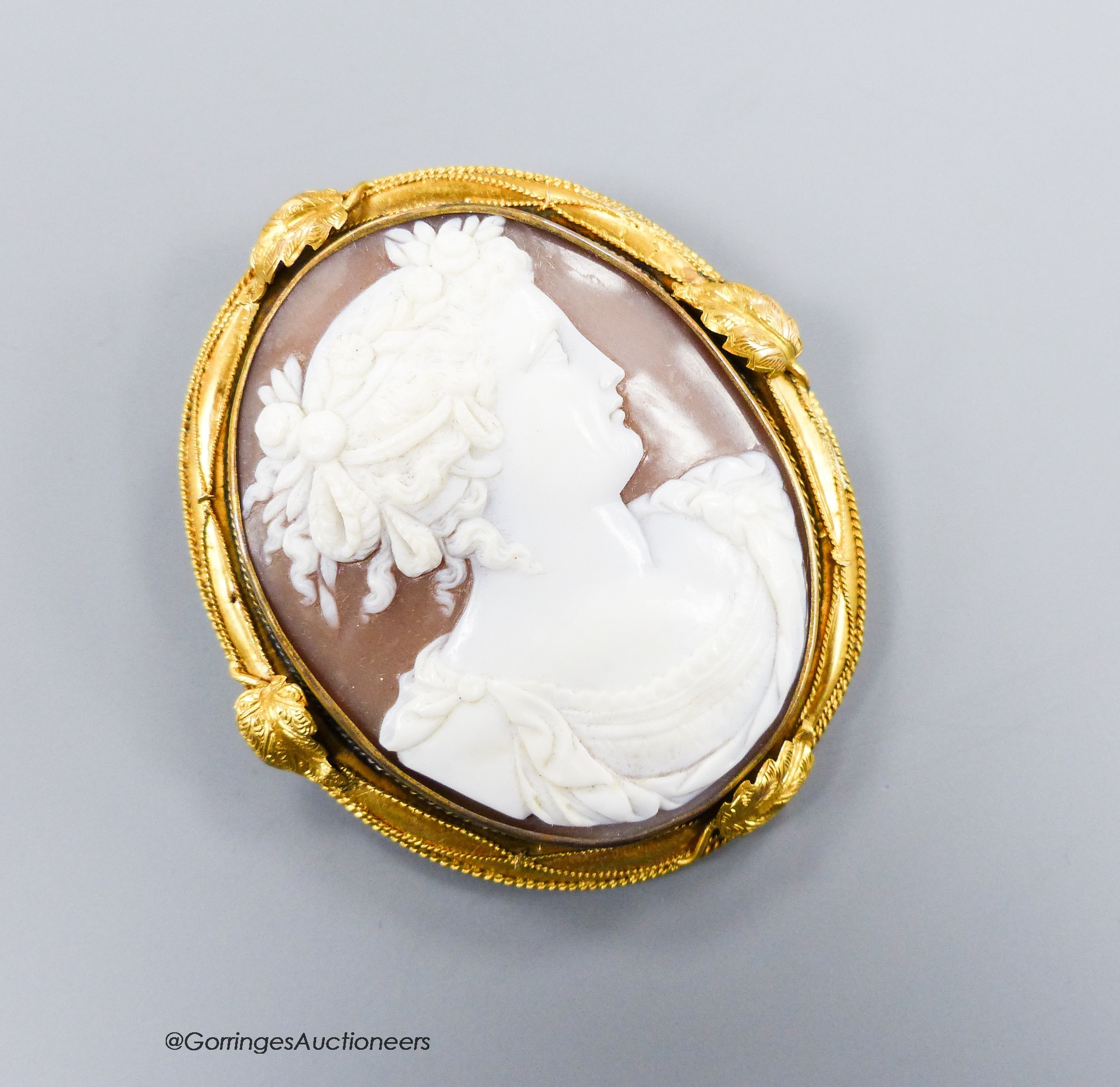 A late Victorian yellow metal mounted oval cameo shell brooch, carved with the bust of a lady to sinister, 6cm, gross weight 22.3 grams.